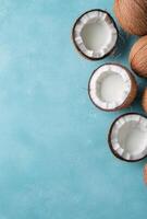 Fresh coconuts with opened shells arranged on a blue background photo