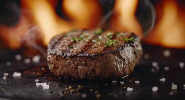Grilled Steak With Herbs on Black Stone Surface Next to Flames photo