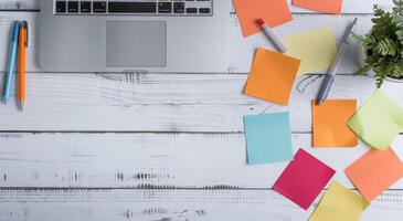 Laptop Surrounded by Colorful Sticky Notes on Wooden Desk photo