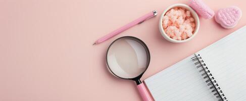 Magnifying Glass on Blank Notebook Surrounded by Neutral Background photo