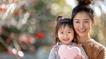 Happy Mother and Daughter Smiling in a Park With Heart-Shaped Pillow in Spring Sunshine photo