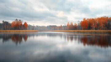 Autumn Reflections Over Tranquil Lake Surrounded by Colorful Foliage in a Cloudy Setting photo