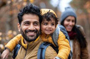 Family Enjoying Autumn Hike in Forest With Child on Father's Back photo