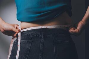 fat woman, fat belly, chubby, obese woman hand holding excessive belly fat with measure tape, woman diet lifestyle concept photo