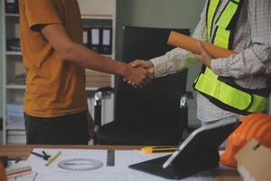 Architect men making handshake in construction site. Employee or worker shake hands to employer man for greeting, dealing, teamwork, collaboration some project or business. They are good team photo