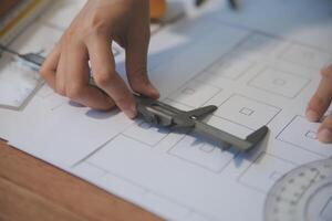 engineer people meeting working and pointing at a blueprint in office for discussing. Engineering tools and construction concept photo