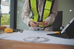 engineer people meeting working and pointing at a blueprint in office for discussing. Engineering tools and construction concept photo