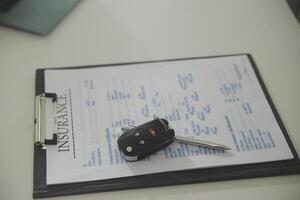 Young man receives a key from car salesman. After agreeing to a contract for rent or sale of a car at workshop, loan car, insurance, sale, buying car and finance concept. photo