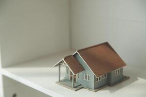 Real estate agent home sales broker is using a pen pointing to the house model and explains the business contract, rent, buy, mortgage, loan, or home insurance photo