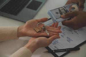 Real estate agent home sales broker is using a pen pointing to the house model and explains the business contract, rent, buy, mortgage, loan, or home insurance photo