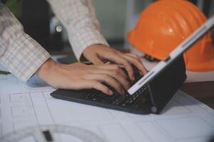 engineer people meeting working and pointing at a blueprint in office for discussing. Engineering tools and construction concept photo