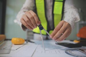 engineer people meeting working and pointing at a blueprint in office for discussing. Engineering tools and construction concept photo