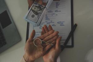 Real estate agent home sales broker is using a pen pointing to the house model and explains the business contract, rent, buy, mortgage, loan, or home insurance photo