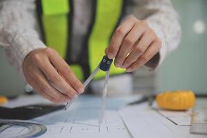 engineer people meeting working and pointing at a blueprint in office for discussing. Engineering tools and construction concept photo