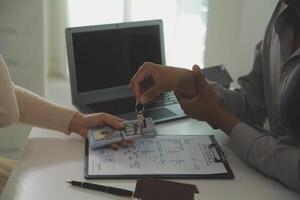 Real estate agent home sales broker is using a pen pointing to the house model and explains the business contract, rent, buy, mortgage, loan, or home insurance photo