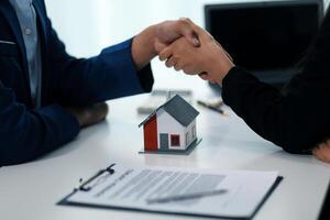 Estate agent shaking hands with customer after contract signature photo