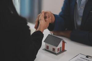 Estate agent shaking hands with customer after contract signature photo