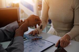 Real estate agent home sales broker is using a pen pointing to the house model and explains the business contract, rent, buy, mortgage, loan, or home insurance photo