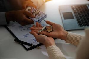 Real estate agent home sales broker is using a pen pointing to the house model and explains the business contract, rent, buy, mortgage, loan, or home insurance photo