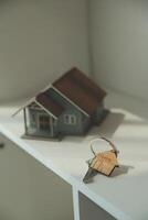 Real estate agent home sales broker is using a pen pointing to the house model and explains the business contract, rent, buy, mortgage, loan, or home insurance photo