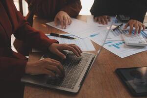 Group of confident business people point to graphs and charts to analyze market data, balance sheet, account, net profit to plan new sales strategies to increase production capacity. photo