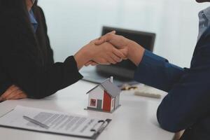 Estate agent shaking hands with customer after contract signature photo