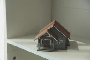 Real estate agent home sales broker is using a pen pointing to the house model and explains the business contract, rent, buy, mortgage, loan, or home insurance photo