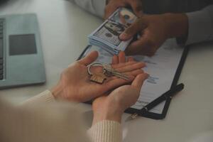 Real estate agent home sales broker is using a pen pointing to the house model and explains the business contract, rent, buy, mortgage, loan, or home insurance photo