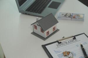 Real estate agent home sales broker is using a pen pointing to the house model and explains the business contract, rent, buy, mortgage, loan, or home insurance photo