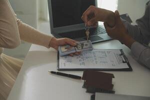 Real estate agent home sales broker is using a pen pointing to the house model and explains the business contract, rent, buy, mortgage, loan, or home insurance photo