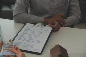 Real estate agent home sales broker is using a pen pointing to the house model and explains the business contract, rent, buy, mortgage, loan, or home insurance photo