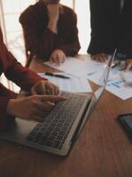 Group of confident business people point to graphs and charts to analyze market data, balance sheet, account, net profit to plan new sales strategies to increase production capacity. photo