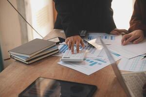 Group of confident business people point to graphs and charts to analyze market data, balance sheet, account, net profit to plan new sales strategies to increase production capacity. photo