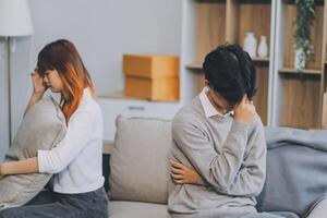 Offended couple ignoring each other after quarrel indoors, selective focus. Relationship problems photo
