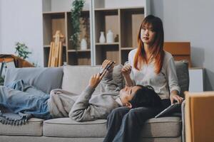 Young Asian couple relocating to a new house, joyfully packing and unpacking belongings. Expertise in moving, packing, togetherness, and creating a new home together. photo