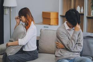Offended couple ignoring each other after quarrel indoors, selective focus. Relationship problems photo