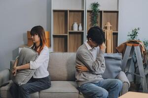 Offended couple ignoring each other after quarrel indoors, selective focus. Relationship problems photo