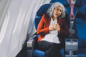 Mature with headache with nausea feeling sick while sitting in the airplane , Passengers near the window. photo