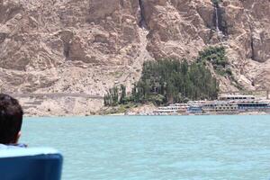 Hunza, Pakistan, 05 July 2024 - Beautiful view of hotels and shops built for tourists on the banks of Attabad Lake in Hunza, Gilgit Baltistan. photo