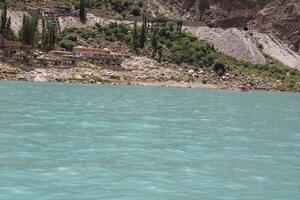 Hunza, Pakistan, 05 July 2024 - Beautiful view of hotels and shops built for tourists on the banks of Attabad Lake in Hunza, Gilgit Baltistan. photo