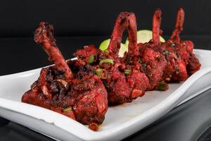 A plate with a Chicken lollipop on it photo