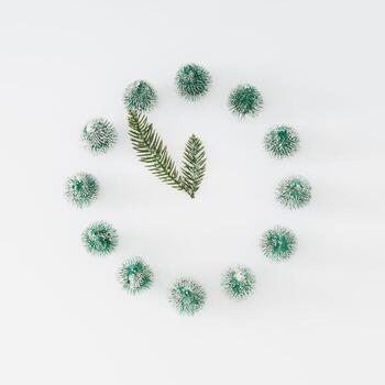 Trendy winter layout of analog clock made with Christmas trees and snowy branches on white background. Minimal time concept. Creative Christmas or New Year's eve idea. Xmas aesthetic. Flat lay. photo