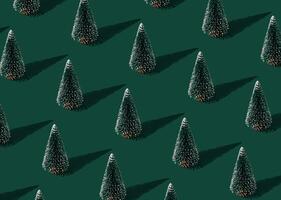 Christmas pattern composition made of green Xmas tree on green background. Creative minimal Christmas and New Year concept. Festive winter holiday pattern backdrop. Christmas aesthetic background. photo
