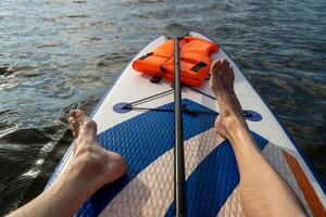 A person paddleboards while enjoying the serene water view photo
