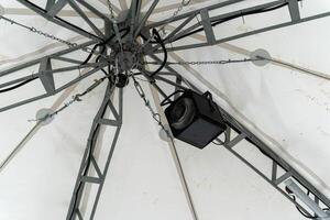 A distinctive lighting fixture hangs from a structural framework photo
