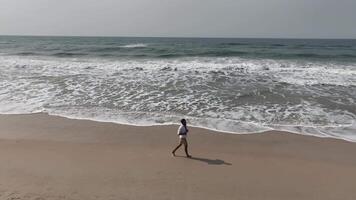Man walking and running on sand dunes near the beach. Aerial image with drone following the man. Image from above. Health concept. video