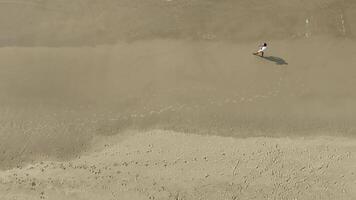 Man walking and running on sand dunes near the beach. Aerial image with drone following the man. Image from above. Health concept. video