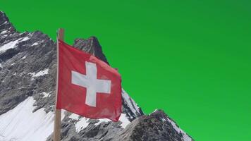 Swiss flag blow and mt.Jungfraujoch against green screen background. Aerial view of red flag of Switzerland and Jungfraujoch crest which is Top of Europe highest mountain Swiss Alps with greenscreen. video