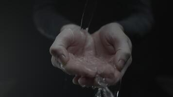Hands cupping water, creating a slow motion splash video