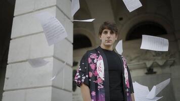 Sheets of paper with musical notes fall on the man video